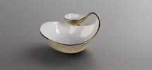 Load image into Gallery viewer, A white porcelain chip and dip bowl with a gold edged design, featuring a smooth finish and a curved handle on the side.